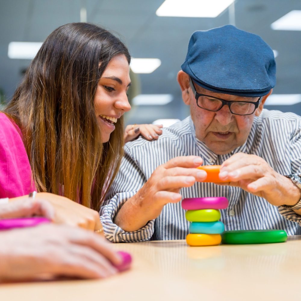 Senior man and nurse playing board game in a nursing home